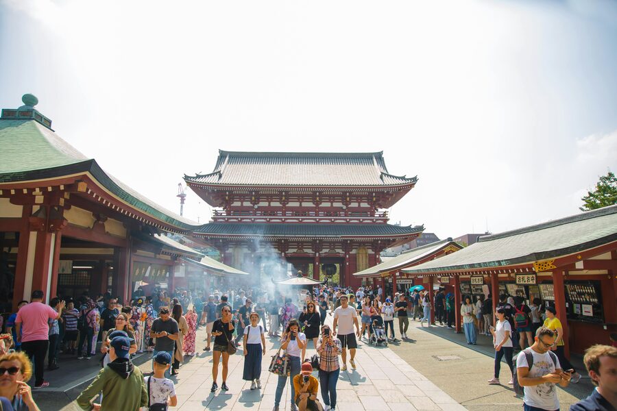 A small tour group walking through Senso-ji temple grounds in Asakusa