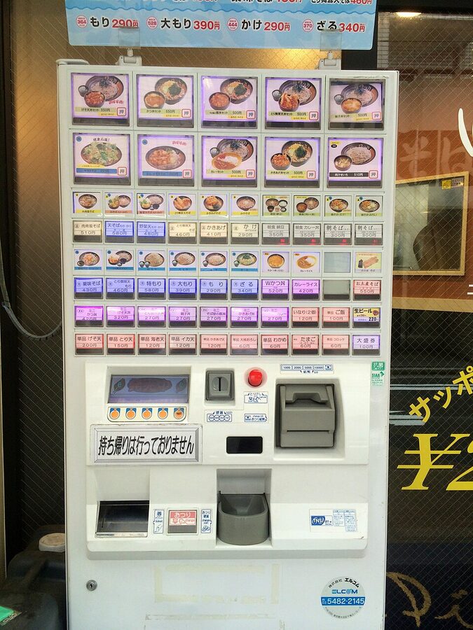 A meal-ticket vending machine outside a small Japanese ramen shop
