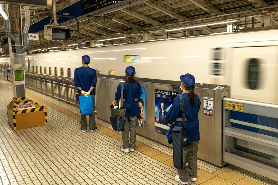 A shinkansen bullet train at a Japanese station platform with the distinctive nose visible